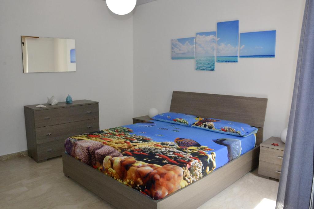 クストナーチにあるCasa Vacanza Tra Cielo e Mareのベッドルーム1室(青い掛け布団付きのベッド1台付)