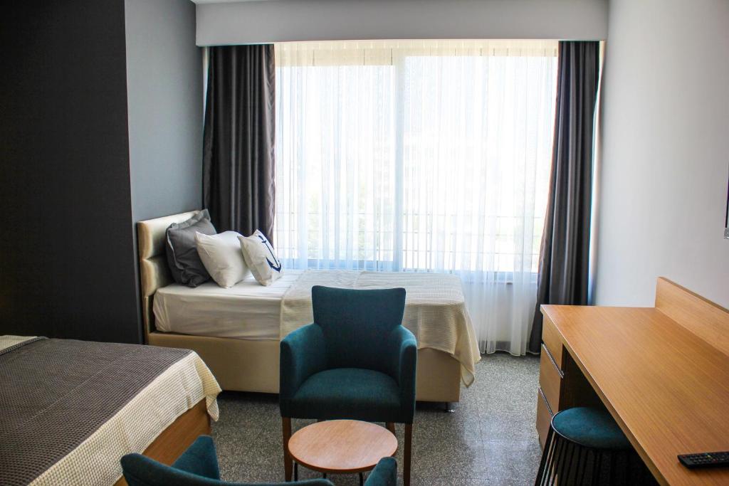 een hotelkamer met een bed, een stoel en een raam bij Port Marina Hotel in Karatas