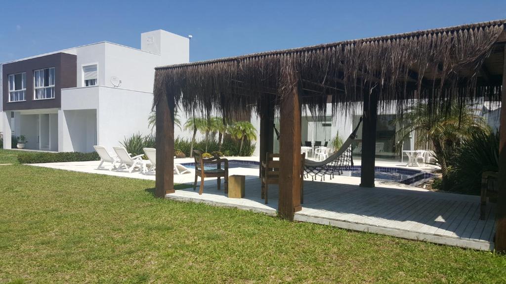 a pavilion with a hammock in a yard at Atlantida Park Residence in Xangri-lá