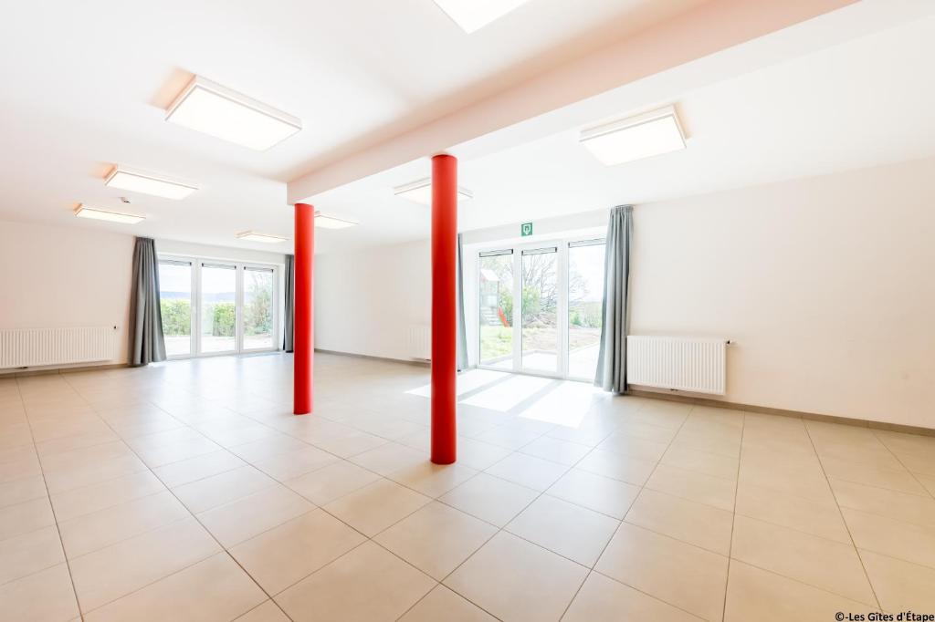 une pièce vide avec des poteaux rouges dans un bâtiment dans l&#39;établissement Gîte Kaleo Eupen Jugendherberge, à Eupen
