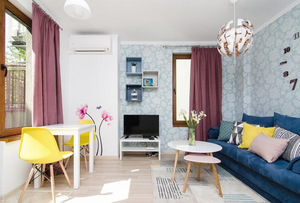 a living room with a blue couch and a table at The Cozy Apartment in Varna City