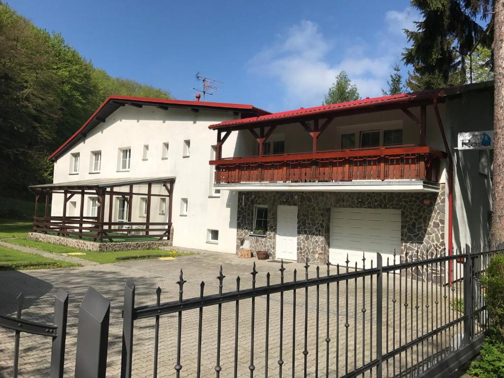 une maison blanche avec une clôture devant elle dans l'établissement Chata Rosa, à Malenovice