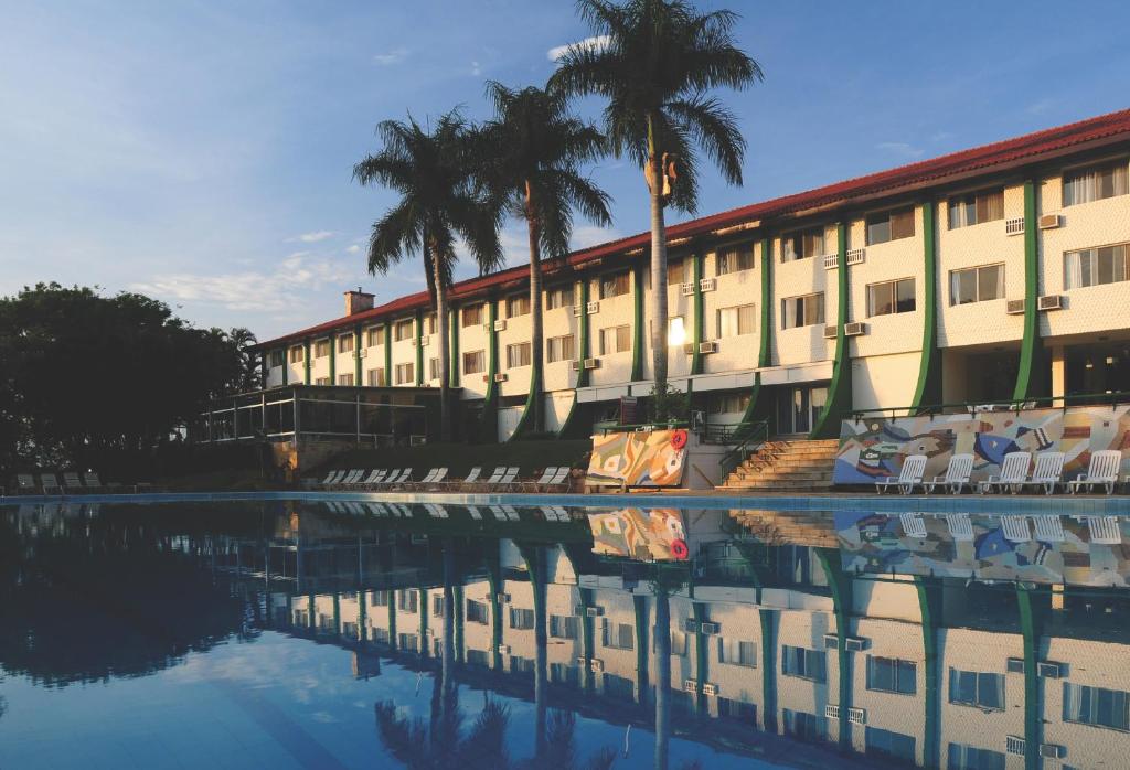 阿蒂巴亞的住宿－Eldorado Atibaia Eco Resort，棕榈树环绕在水体上的建筑
