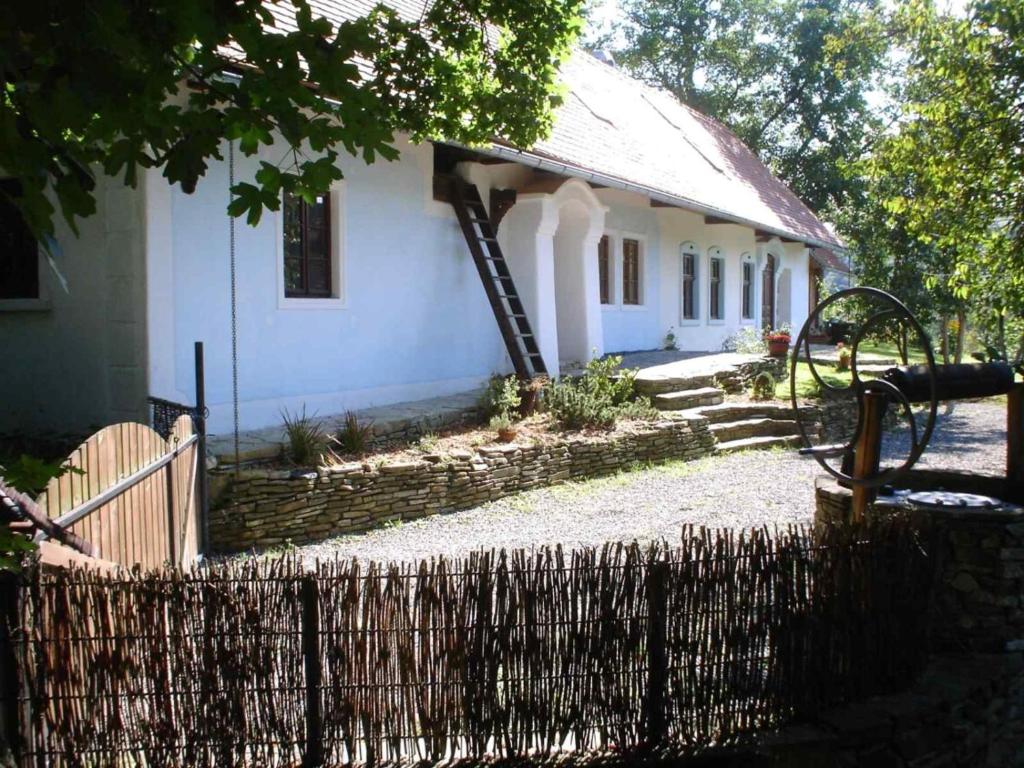 ein weißes Haus mit einem Zaun davor in der Unterkunft Historický objekt Ailit in Podbranč