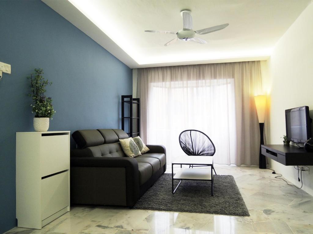 a living room with a couch and a ceiling fan at G2 Holiday Apartment in Melaka