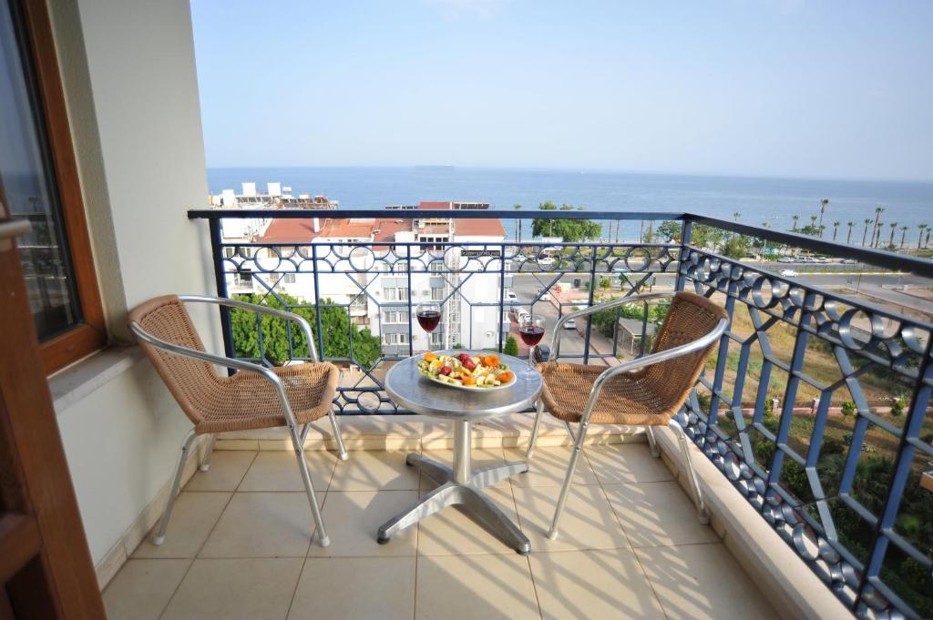 a balcony with a table and two glasses of wine at Hotel Royal Hill in Antalya