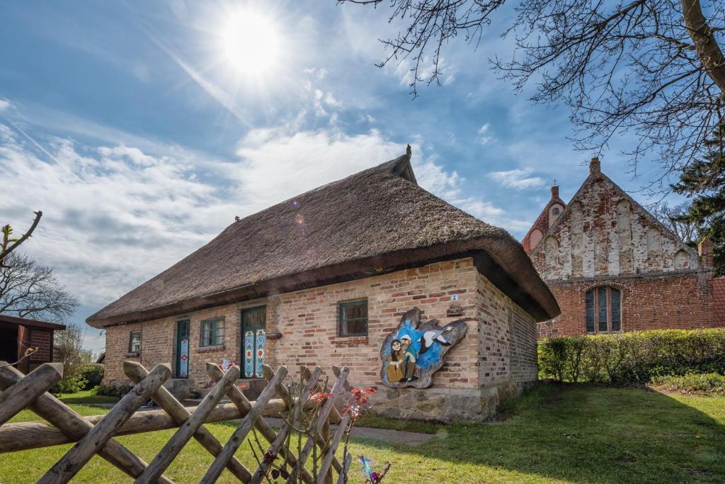 een oud bakstenen gebouw met een rieten dak bij Hexenhaus auf Rügen in Rappin