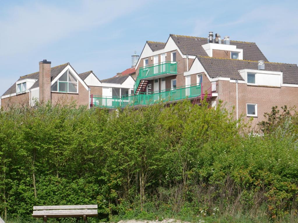 uma fila de casas numa colina com um banco em Huize de Duinen em Bergen aan Zee