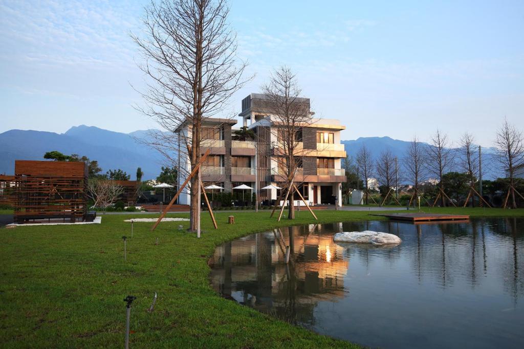a building next to a pond with a house at 193 County Garden BnB in Jian