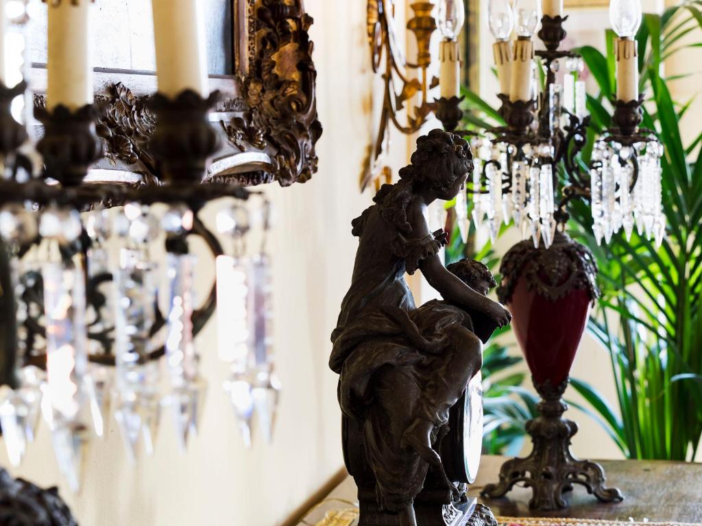 a statue of a cherub on a table next to a chandelier at Hotel Sirius in Taormina