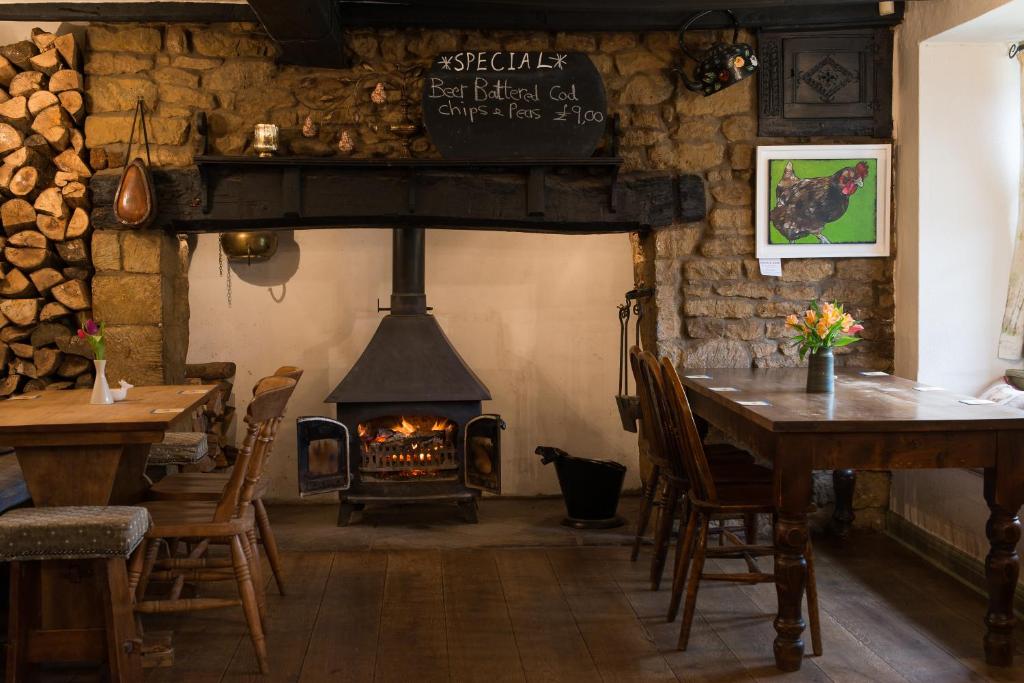 um restaurante com lareira, mesa e cadeiras em Stag's Head em Banbury