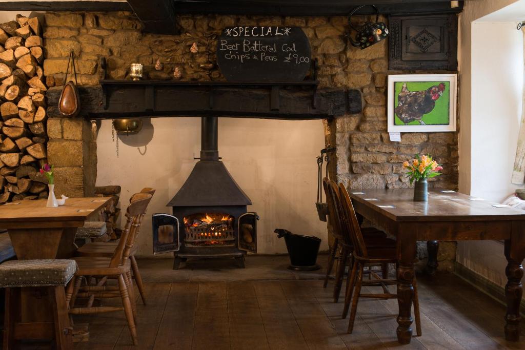 a restaurant with a fireplace and a table and chairs at Stag's Head in Banbury