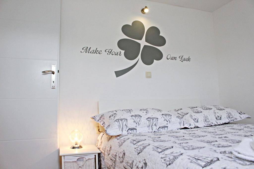 1 dormitorio con 1 cama con una flor en la pared en Apartment Ada, en Zadar