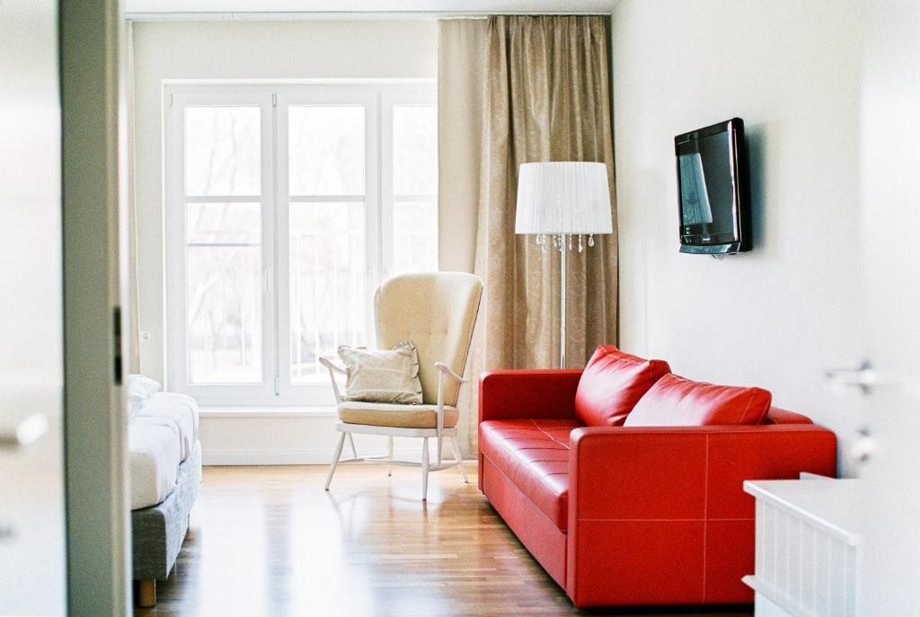 ein Wohnzimmer mit einem roten Sofa und einem Stuhl in der Unterkunft Domizil Gols, Boutique - Hotel in Gols
