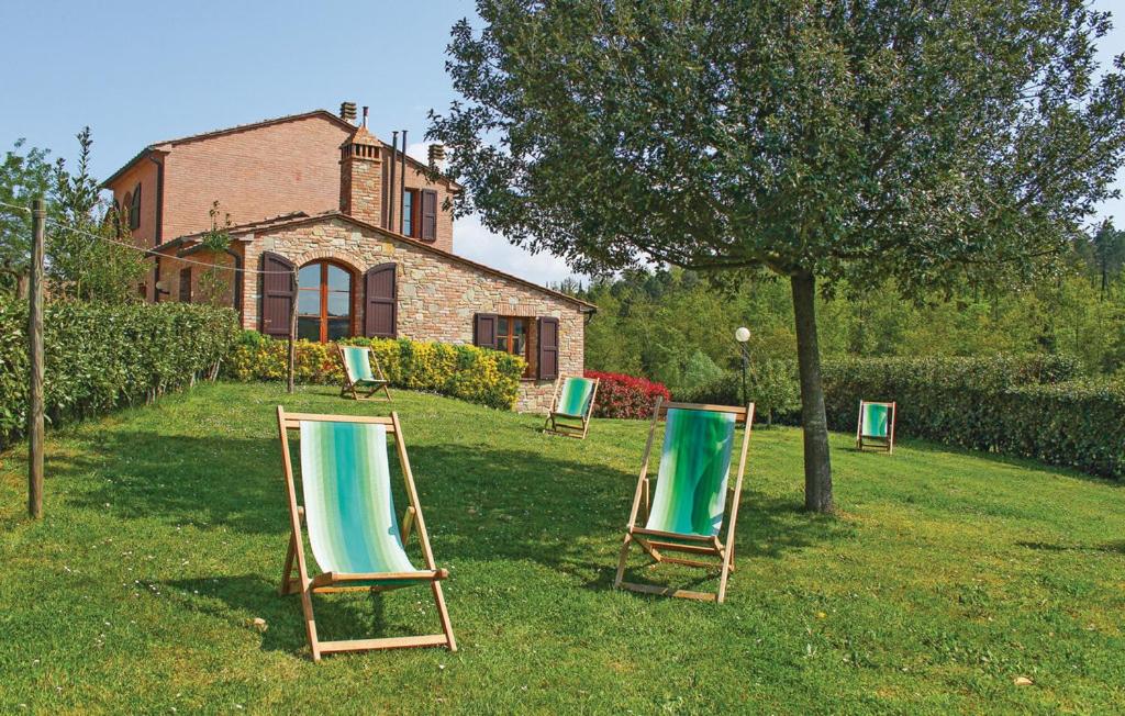two lawn chairs sitting in the grass in front of a house at Borgo degli Orti in Montaione