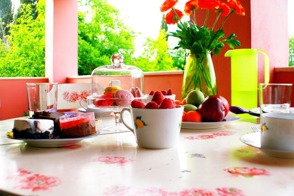 Corfu Villa Galini في Potamós: طاولة مع أطباق من الطعام و مزهرية مع الزهور