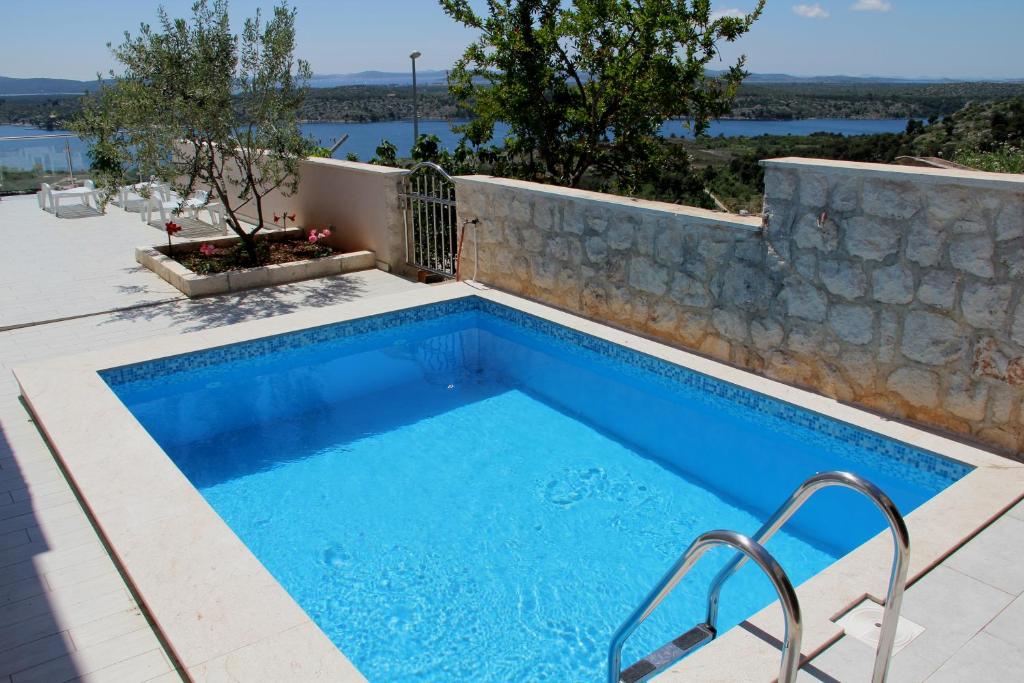 uma piscina com uma parede de pedra e uma piscina em Apartment Sunset em Sibenik