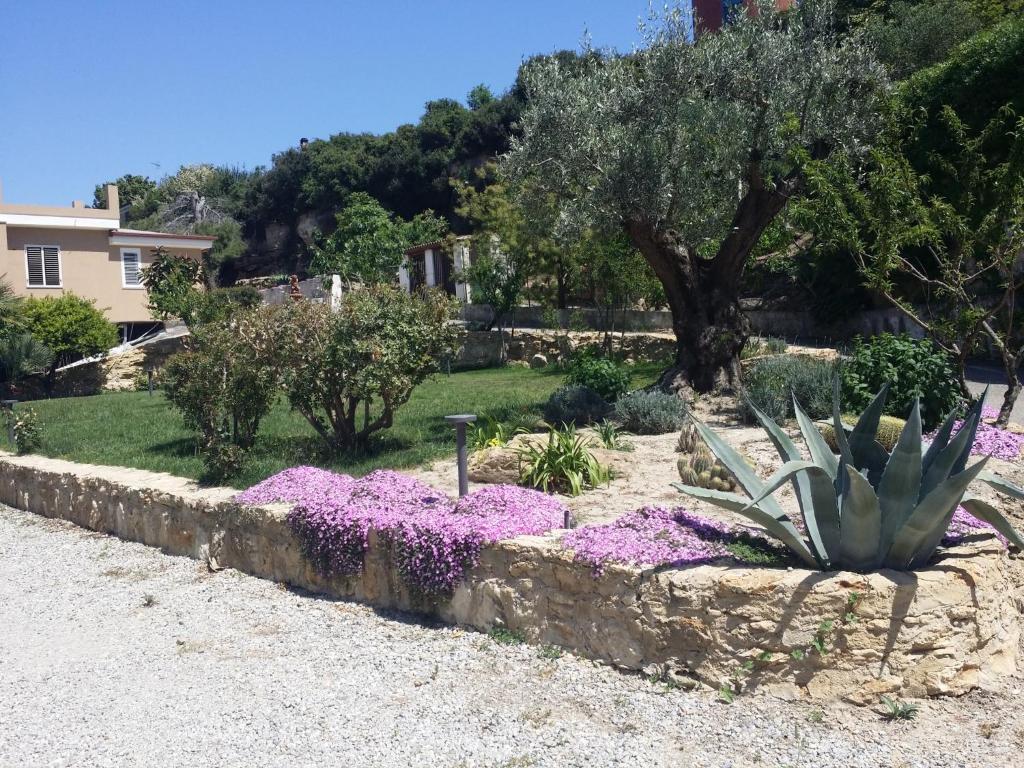 a garden with purple flowers and a tree at Le Castella B&B Restaurant in Le Castella