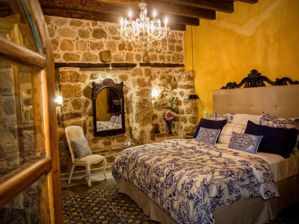 een slaapkamer met een bed en een stenen muur bij George & Alexandra's Apartments in Rhodos-stad