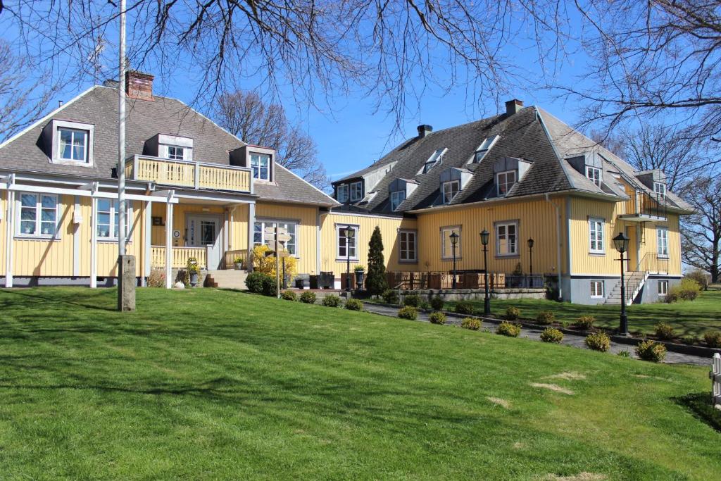 una gran casa amarilla con patio en Hotel Tanum Gestgifveri, en Tanumshede