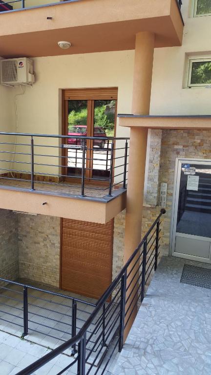 Vrnjačka BanjaにあるAlex apartmanのドアとバルコニーのあるバルコニー付きの家