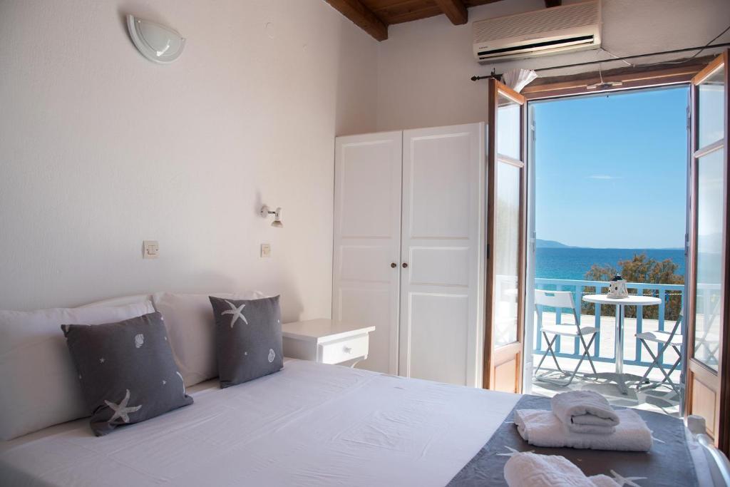 sypialnia z dużym łóżkiem i balkonem w obiekcie Fisilanis Beachfront Hotel w mieście Logaras
