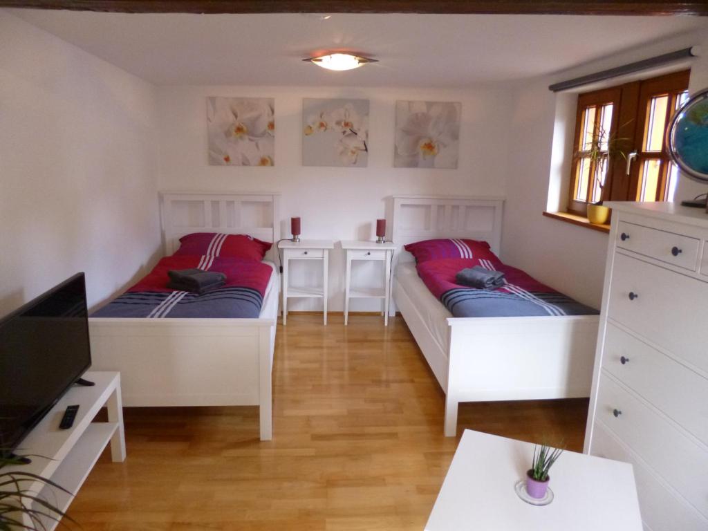 two beds in a room with a table and a tv at Ferienwohnung Jansen "Eins" in Bad Schwalbach