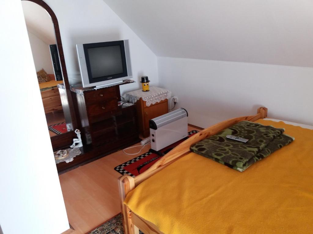 a bedroom with a bed and a tv in a room at Rita vendégház in Villány