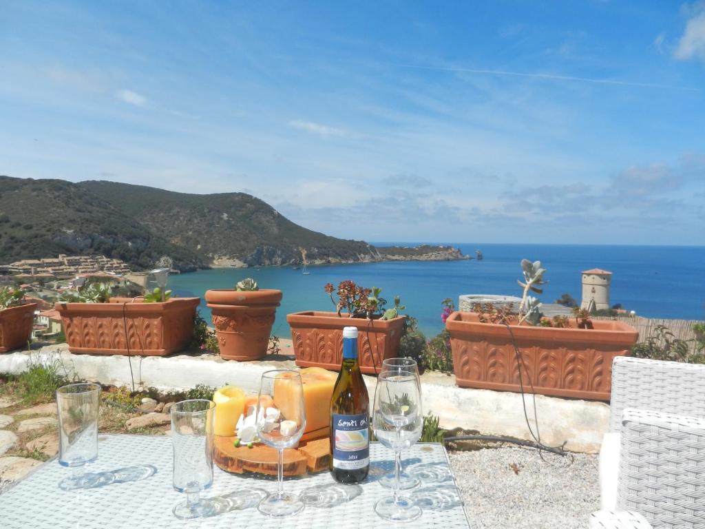 una bottiglia di vino seduta su un tavolo con vista sull'oceano di Villa Giglio Rosso a Campese