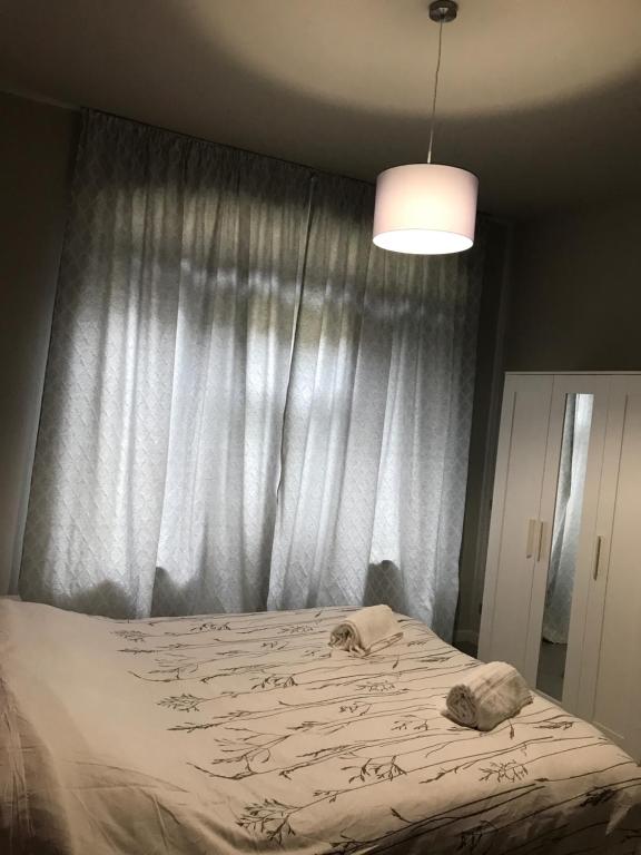 um quarto com uma cama grande e uma cortina em Casa Mirabello em Peveragno