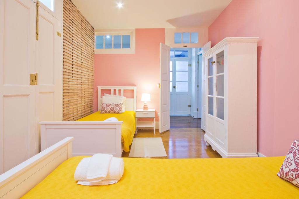 ポルトにあるPorto Sé Apartamentosのベッド2台と廊下が備わる小さな客室です。