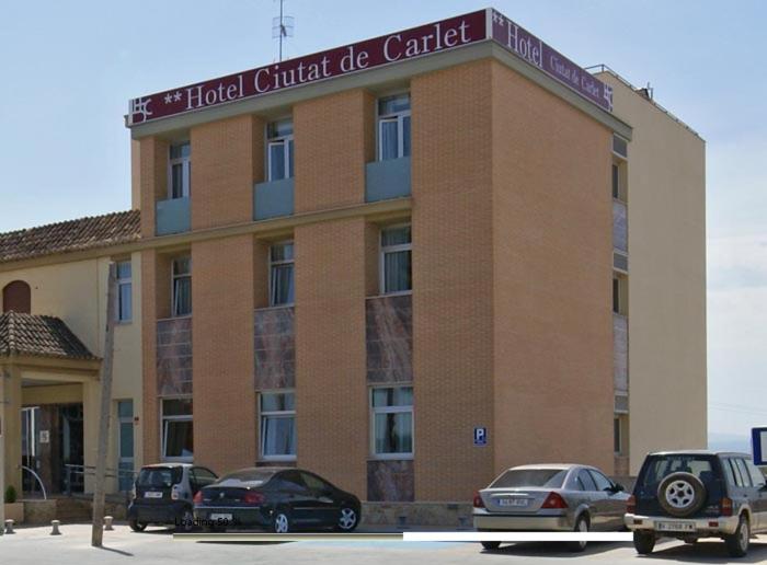 a building with cars parked in front of it at Hotel Ciutat de Carlet in Carlet