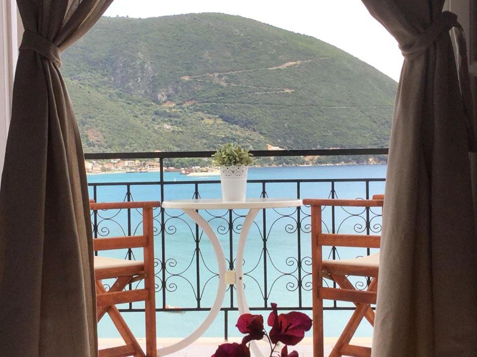 a balcony with a table and chairs and a view of the water at Sea Sound in Vasiliki
