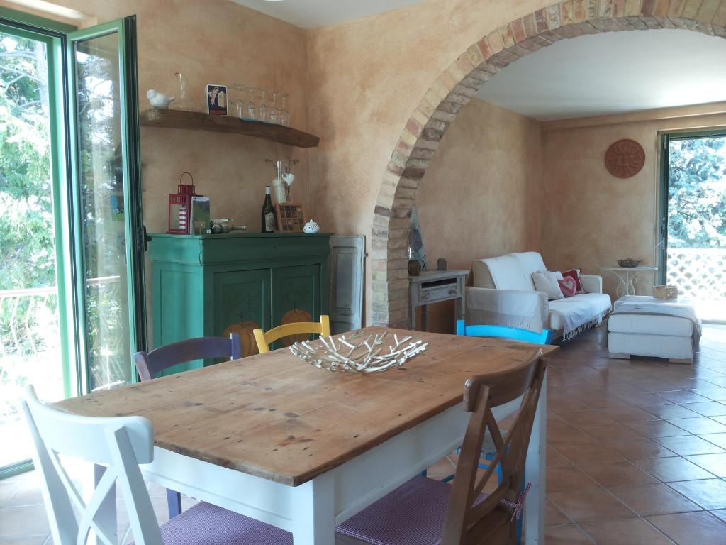 uma sala de jantar com uma mesa de madeira e cadeiras em Casale Vittoria em Atri