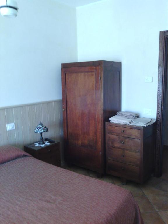 ピエディルコにあるI Cavalieri Del Lagoのベッドルーム(ドレッサー、木製キャビネット付)