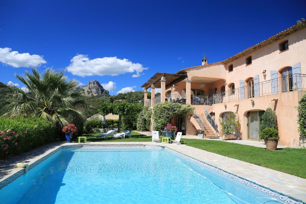 eine Villa mit einem Pool vor einem Haus in der Unterkunft La Bastide de Freinet in Vence