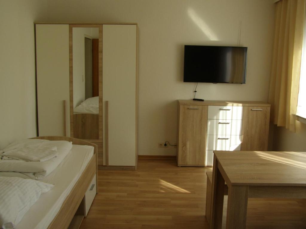 a bedroom with a bed and a table and a mirror at Apartment Bexor D19 in Hannover