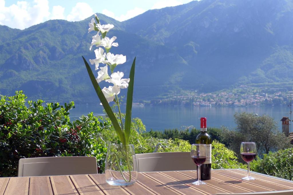 una mesa con una botella de vino y una flor en Bellagio Lake View Villa, en Oliveto Lario