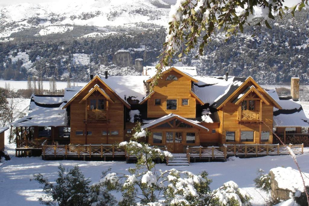 a log cabin in the snow with snow at Sieteflores Hosteria De Montaña in San Martín de los Andes