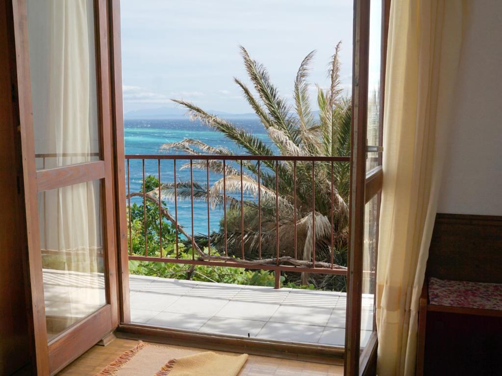 una puerta abierta a un balcón con vistas al océano en Apartments Feral, en Baška Voda