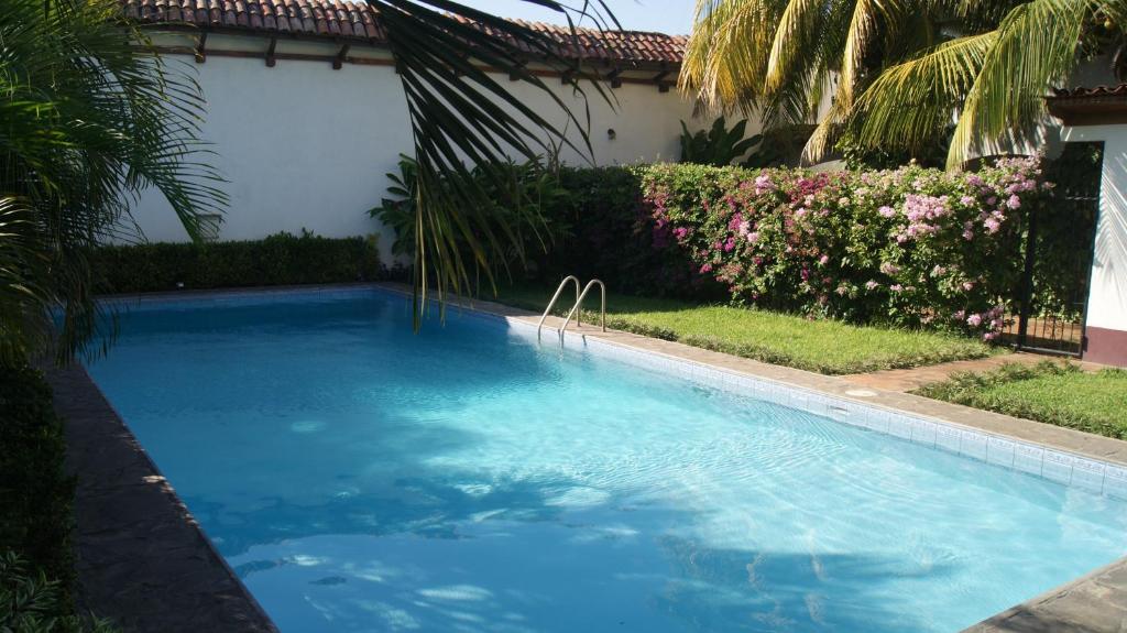 einen Pool mit blauem Wasser im Hof in der Unterkunft Hotel Cacique Adiact in León