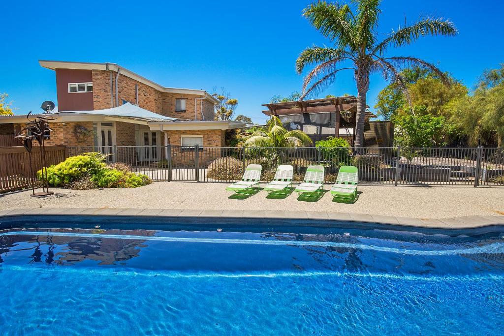 Una piscina con tumbonas y una casa. en Paw Up Villa - entertainer delight, en Rye