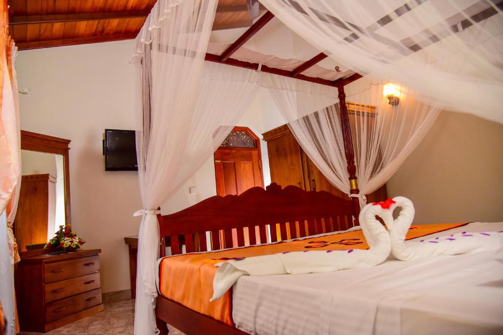 una camera da letto con 2 cigni in asciugamani su un letto di Lucky Prince Villa ad Aluthgama