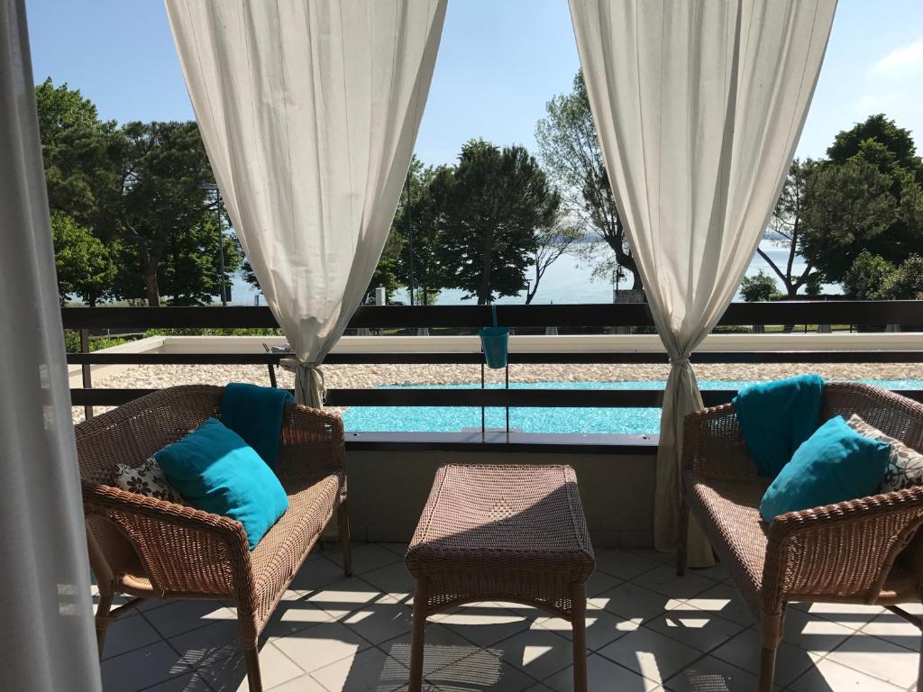a patio with chairs and a swimming pool at Residence Alexandra Stay in Sirmione