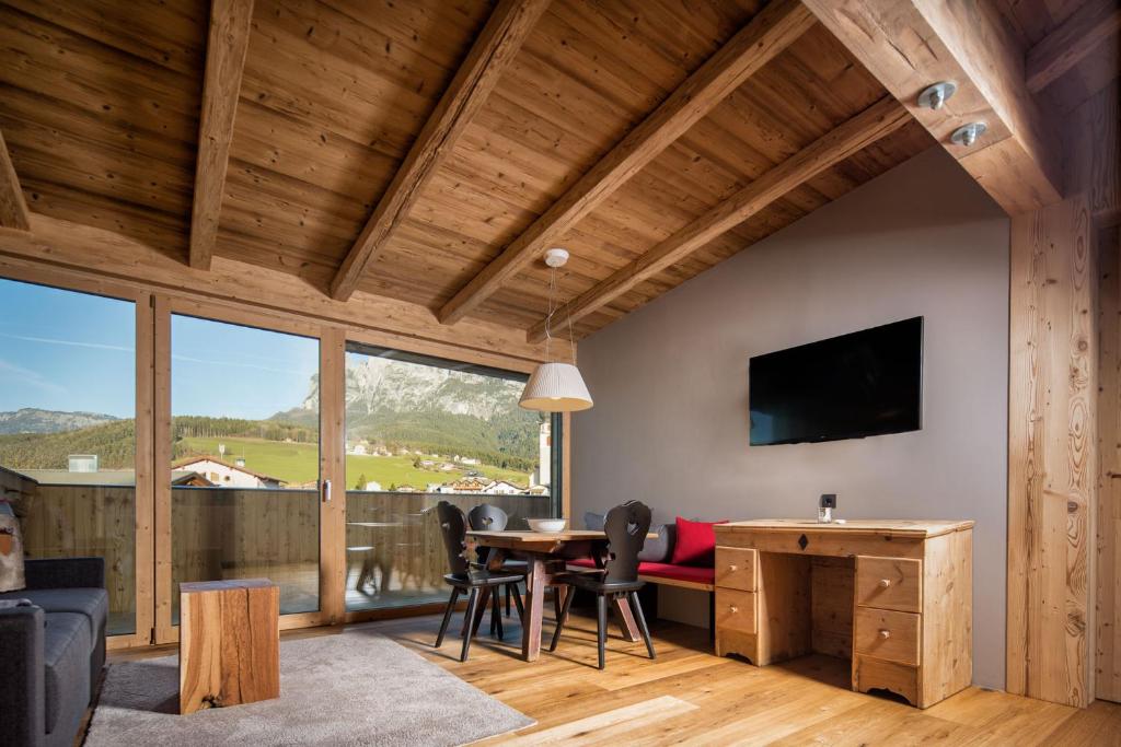 a living room with a table and chairs and a television at hubertus dolomites in Völs am Schlern