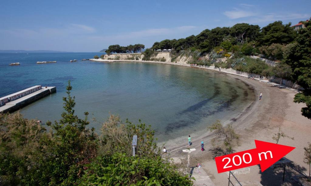 a view of a beach with a sign at Apartments Beautiful Sandy Beach in Split