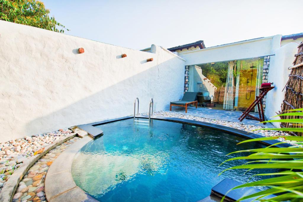 a swimming pool in the backyard of a house at Paatlidun Safari Lodge, Jim Corbett in Garjia