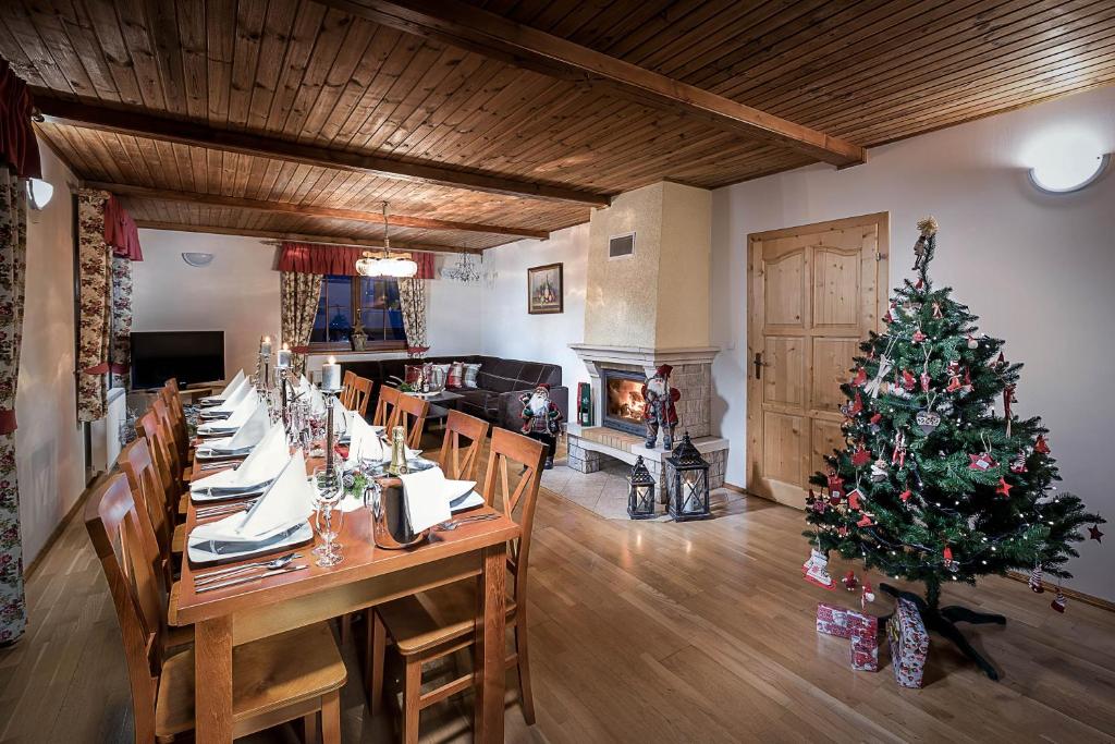 een lange tafel met een kerstboom in een kamer bij Chata Adamec in Ždiar