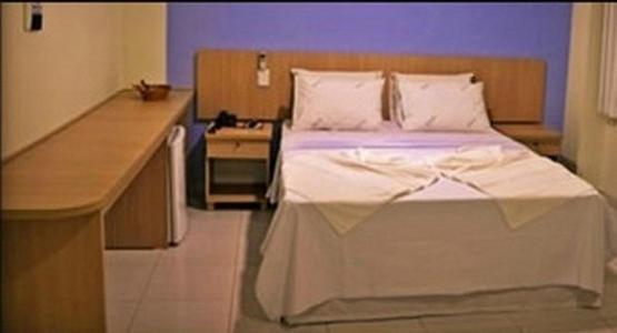 Habitación hospitalaria con cama y escritorio en Hotel Ceolatto Palace - Aeroporto, en Várzea Grande
