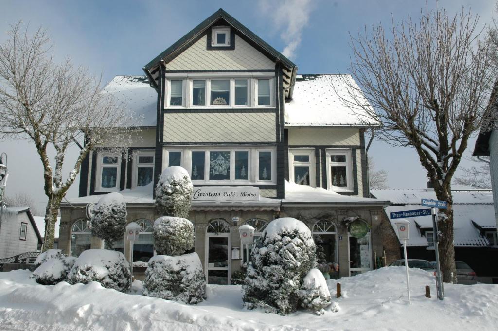uma casa coberta de neve com estátuas à sua frente em Extrablatt em Oberhof